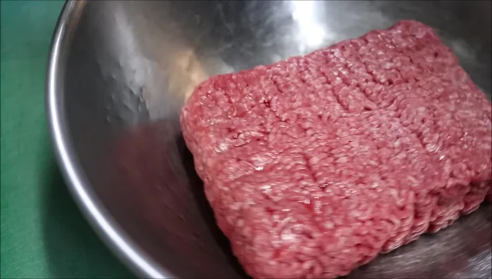 Break up the 1kg of ground lamb and add it to the bowl with the other ingredients.