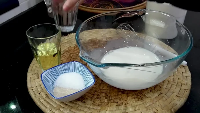 Combine warm milk, warm water, oil, baking yeast, and sugar in a bowl. Mix well.