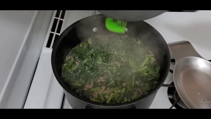 Add the garlic-coriander mixture to the cooked spinach.