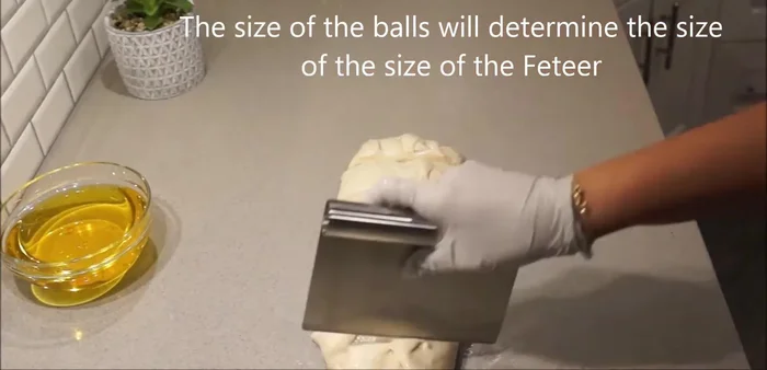 Divide the dough into balls. Use melted Crisco on your work surface and the dough balls. Press and stretch each ball.