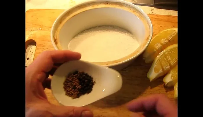 Prepare the spice mixture: Mix coarse salt, coriander seeds, and black peppercorns in a dish. Arrange lemon slices in the dish, ensuring a snug fit.