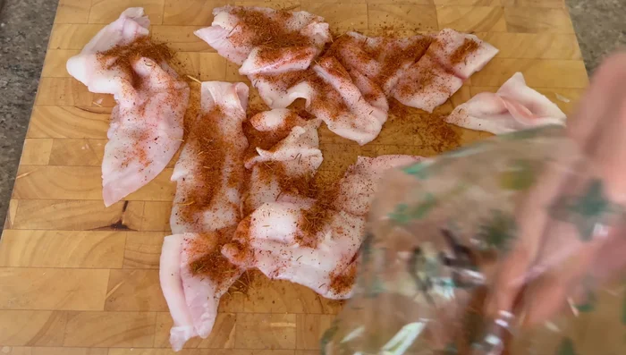Season the fish with fish spice and dredge in the flour mixture.