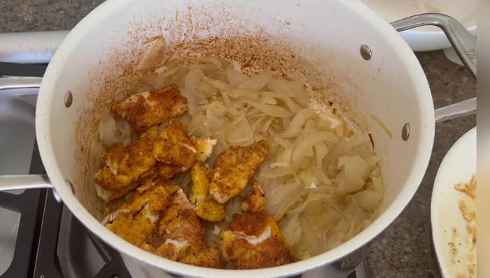 In a pot, layer the caramelized onions, then the partially cooked fish, and finally the seasoned rice.