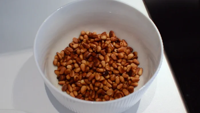 Transfer the toasted pine nuts to a bowl and set aside. Fry the diced onions in the remaining oil until translucent.