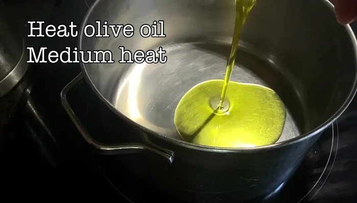 Heat olive oil in a pot on medium-high heat. Add minced garlic, cumin, and chili pepper (or harissa). Stir until fragrant.