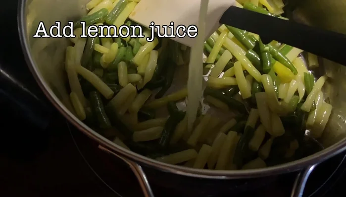 Add lemon juice, salt to taste, and chopped fresh herbs to the green beans. Mix well.