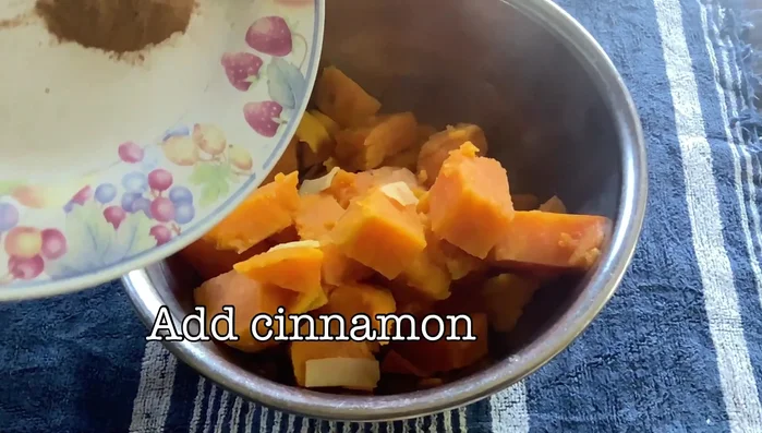 Once cooked, transfer the contents to a bowl. Add cinnamon and butter chunks. Mash everything together.