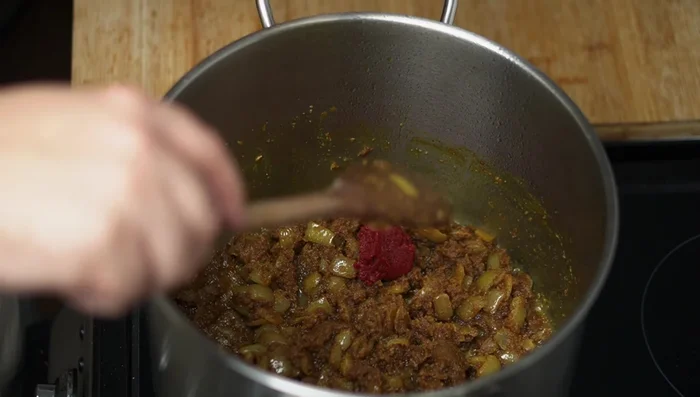 Add tomato paste (optional). Add pomegranate molasses and mix well. Cook for a couple of minutes.