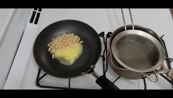 While the chicken cooks, roast pine nuts in 1/4 cup of ghee in a small frying pan over medium heat until lightly browned. Transfer to a strainer.