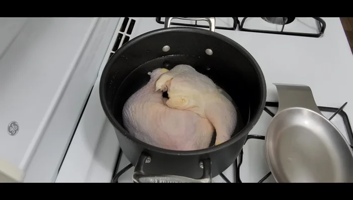 In a medium-sized pot, combine 8 cups of water and 1 kg of chicken thighs (or a whole chicken). Cover and bring to a boil over high heat until foam appears.