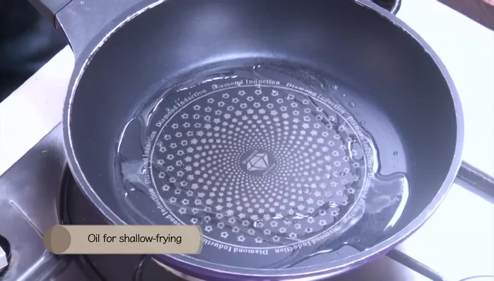Heat oil in a pan over medium heat. Dip each semolina-coated chicken piece in the egg mixture.