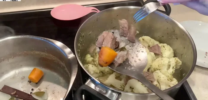 Once the meat is cooked, strain the broth and remove the meat. Pour the broth over the cauliflower. Do not add extra water. Add salt and seven spices. Stir gently from the bottom up.