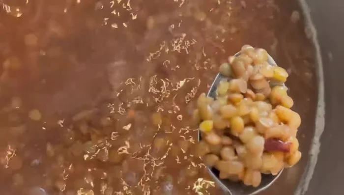 After 20 minutes, check the lentils for tenderness. Add 1 cup of rice, half of the caramelized onions, 1/4 teaspoon of seven spice, and salt to the lentils. Stir well.
