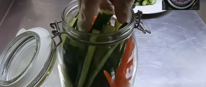 Pack a jar with chopped cucumbers, chilies, and whole garlic cloves.