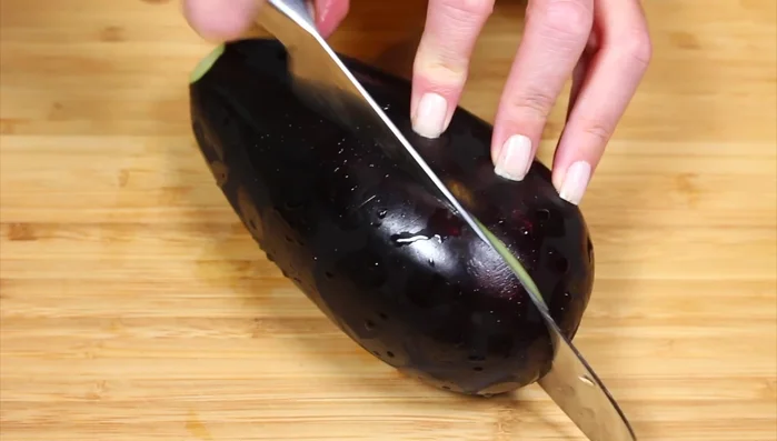 Cut the eggplant in half, then in quarters, and finally slice it.
