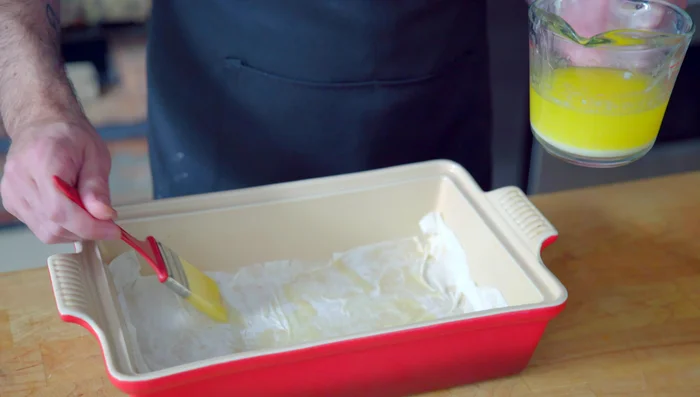 Add one-third of the nut mixture, spread evenly. Repeat with two more phyllo layers and nut mixture. Top with six more layers of phyllo, brushing each with butter.