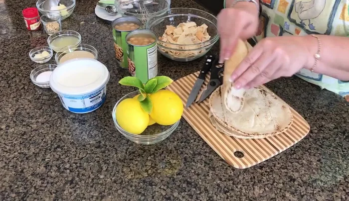 Prepare the pita bread: Cut the pita bread into small pieces.