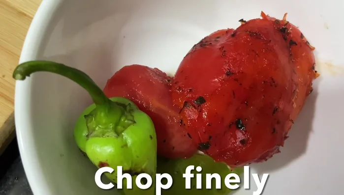 Finely chop the roasted tomatoes, bell peppers, green chilies, and onions.