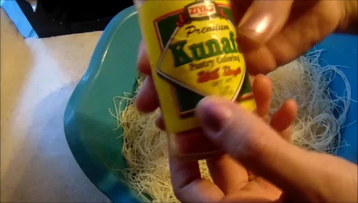 In a bowl, mix the shredded phyllo dough with kunafa coloring and butter until a nice orange color is achieved.