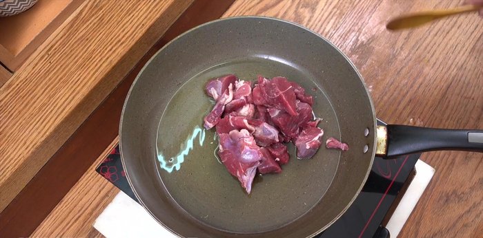 Heat olive oil in a pot or pan over high heat. Add beef, salt, and pepper. Fry for 4 minutes until slightly browned.