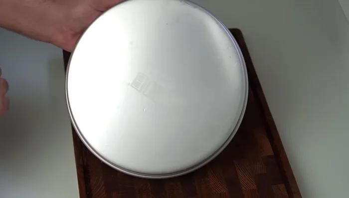 Grease a 10-inch round cake pan with the reserved clarified butter. Add the kunafa pastry to form an even base, pressing it down firmly with a flat, heavy object.