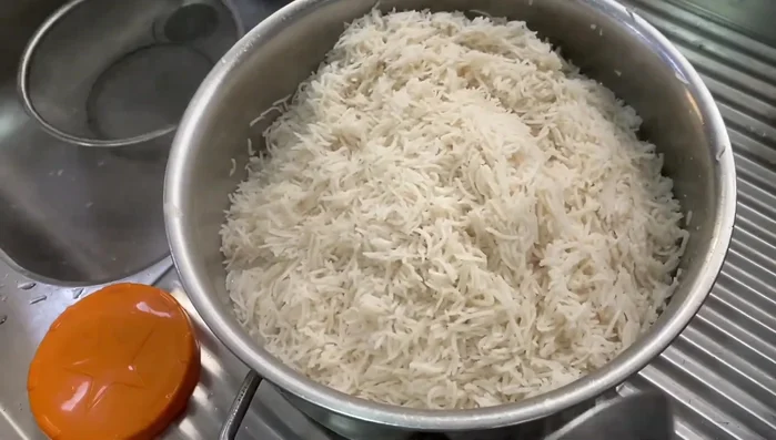 Repeat layering: rice, cardamom powder, rose water, ghee, and 1.5 cups sugar.