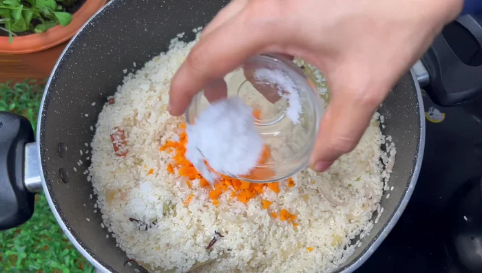 Add rice, a little chopped carrot, salt, and water. Cook for 30 minutes, or until the rice is well cooked.