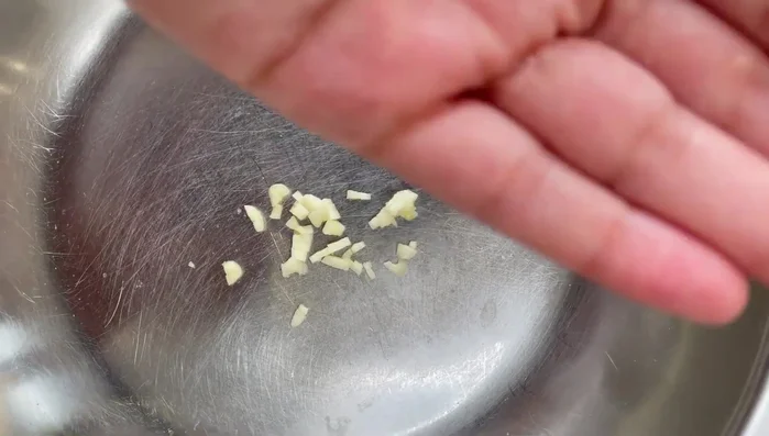 Mince a small clove of garlic. You can use a garlic crusher or chop it finely and squish it with a fork and some salt.