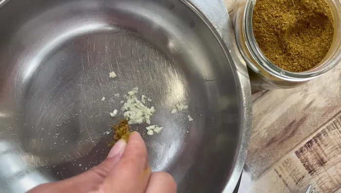 Add a pinch of cumin (or cumin herb spice blend) to the minced garlic.