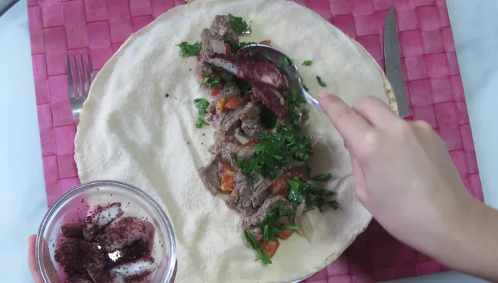 Add chopped parsley, spiced onions, and tahini sauce.