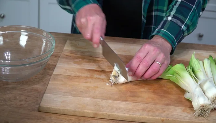 Dice the leeks: Shave off the root end, split the leek in half twice, and make narrow crosswise cuts (105).