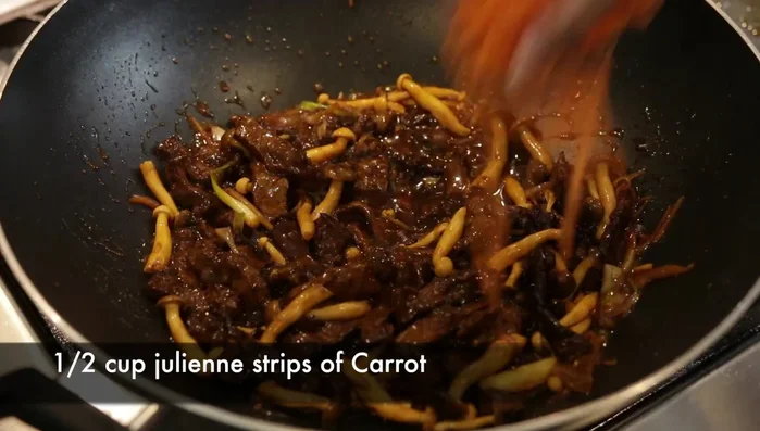 Stir in julienned carrots. Garnish with spring onion leaves.