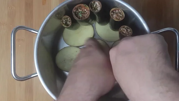 Place stuffed aubergines upright and peppers in the center of the pot on top of the potatoes.