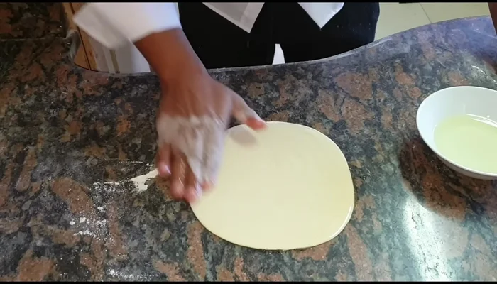 Oil the rolled-out rotis using your fingers or a brush to ensure even coverage.