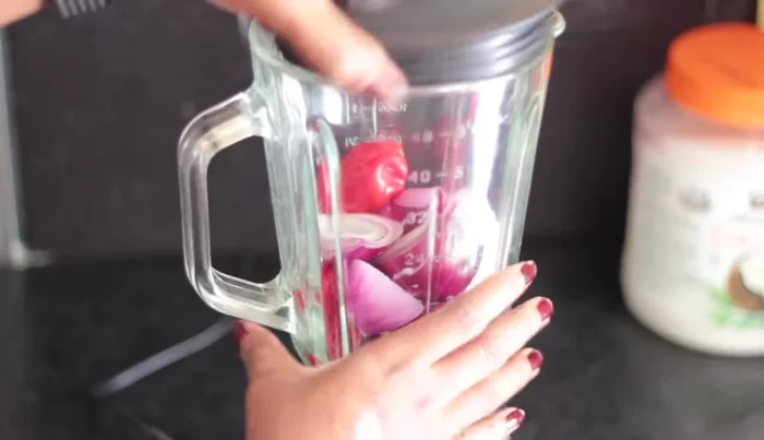 Blend 3 red onions and 4 scotch bonnet peppers (adjust to your spice preference).