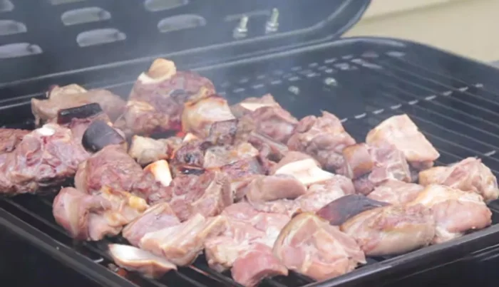 Check on the smoked goat meat, turn it over, and cook for another 25 minutes.