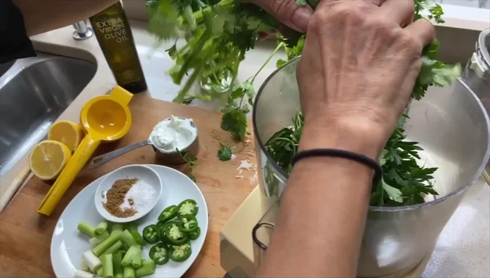 Make the Creamy Green Harissa: Combine cilantro, parsley, jalapeno, scallion, salt, cumin, yogurt, lemon juice, and olive oil in a food processor; pulse until smooth.