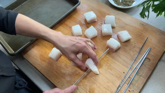 Thread halibut onto skewers (soak wooden skewers if using).