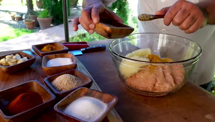 In a large bowl, combine the ground chicken, chopped onions (with their juice), salt, turmeric, black pepper, paprika, citric acid, bread crumbs, sour cream, butter, saffron, and minced garlic.