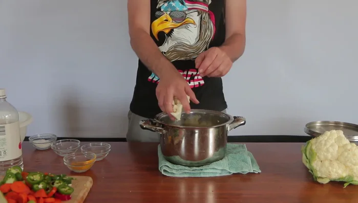 Add the prepared cauliflower, peppers, carrots, celery, and turnip to the boiling water.