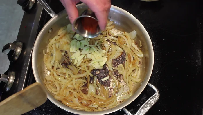 Add the sliced garlic, paprika, and sumac. Stir until fragrant.