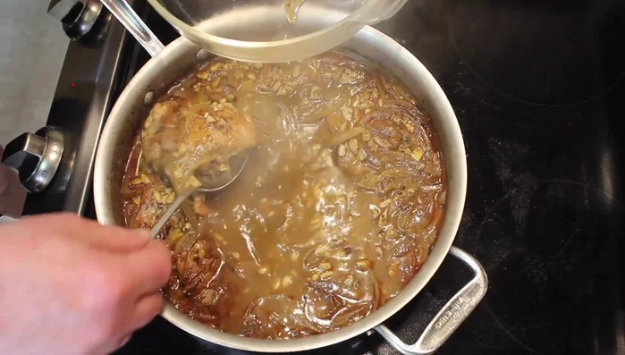 Remove the chicken and shred it. Reduce the sauce by turning up the heat slightly.