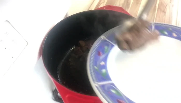 Remove the browned beef and set aside. In the same pot, add more olive oil and caramelize the sliced onions.