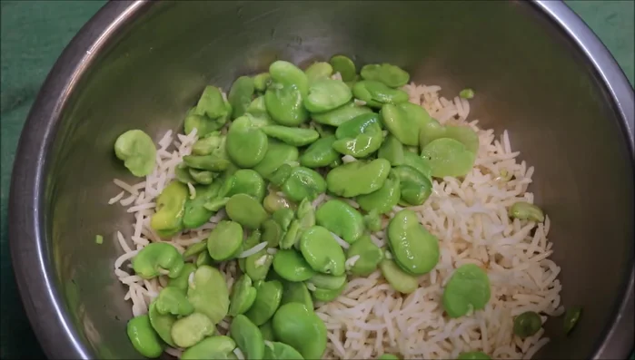 In a bowl, combine three cups of cooked rice, the drained broad beans, saffron water, cinnamon, oil (or butter), and dried dill.