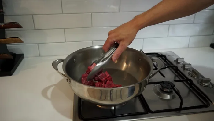 Brown the beef: In a large pan over medium-high heat with olive oil, brown the beef in batches, seasoning with salt.