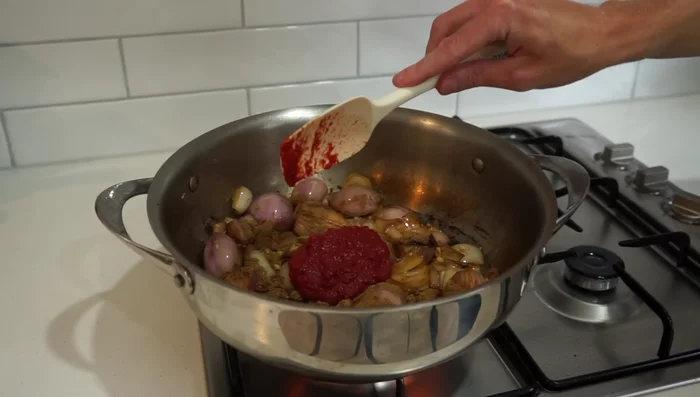 Add spices and tomato paste: Add ground cumin and tomato paste, cook for 1 minute.