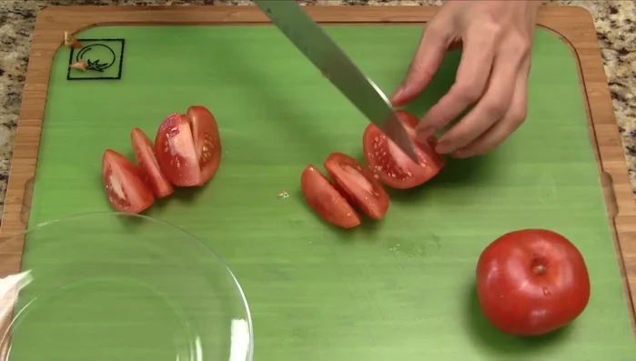 Cut the tomatoes in half, then into wedges. Separate the stems from the white part of the green onions. Cut the white parts into 2-inch slivers and the green stems into 2-inch sections.