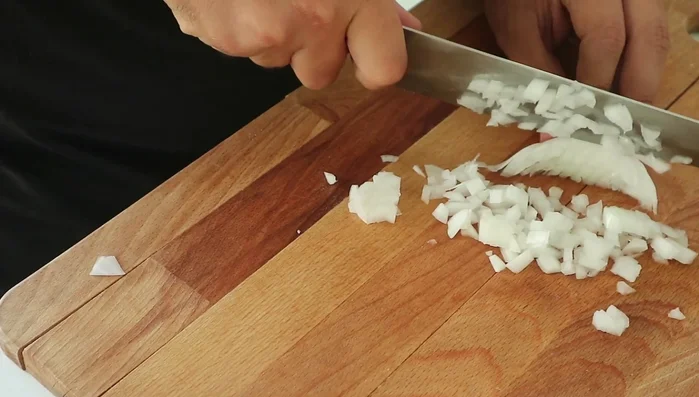 Dice one onion and finely grate two garlic cloves to create a smooth garlic paste. Dice the tomatoes into small cubes and blend them.