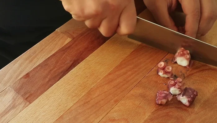 Heat a Moroccan clay pan over medium heat and add a splash of olive oil. Sauté the diced onions until they soften.