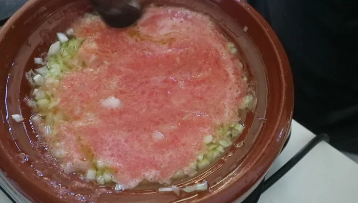 Incorporate the blended tomatoes and tomato puree, mixing well.